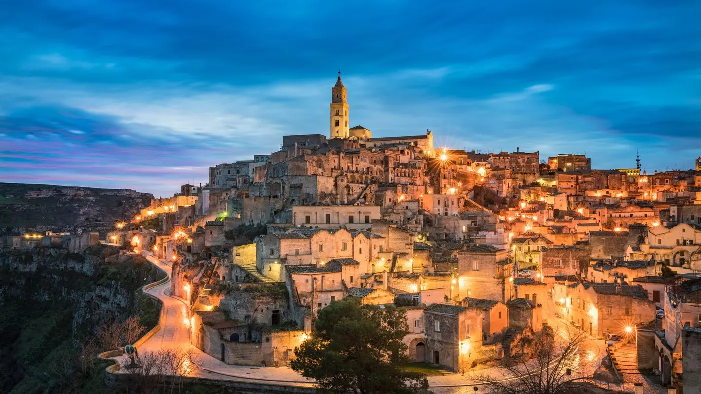 Matera at blue hour: the Sassi cave dwellings lit up across the ravine, a UNESCO site and a hotel district