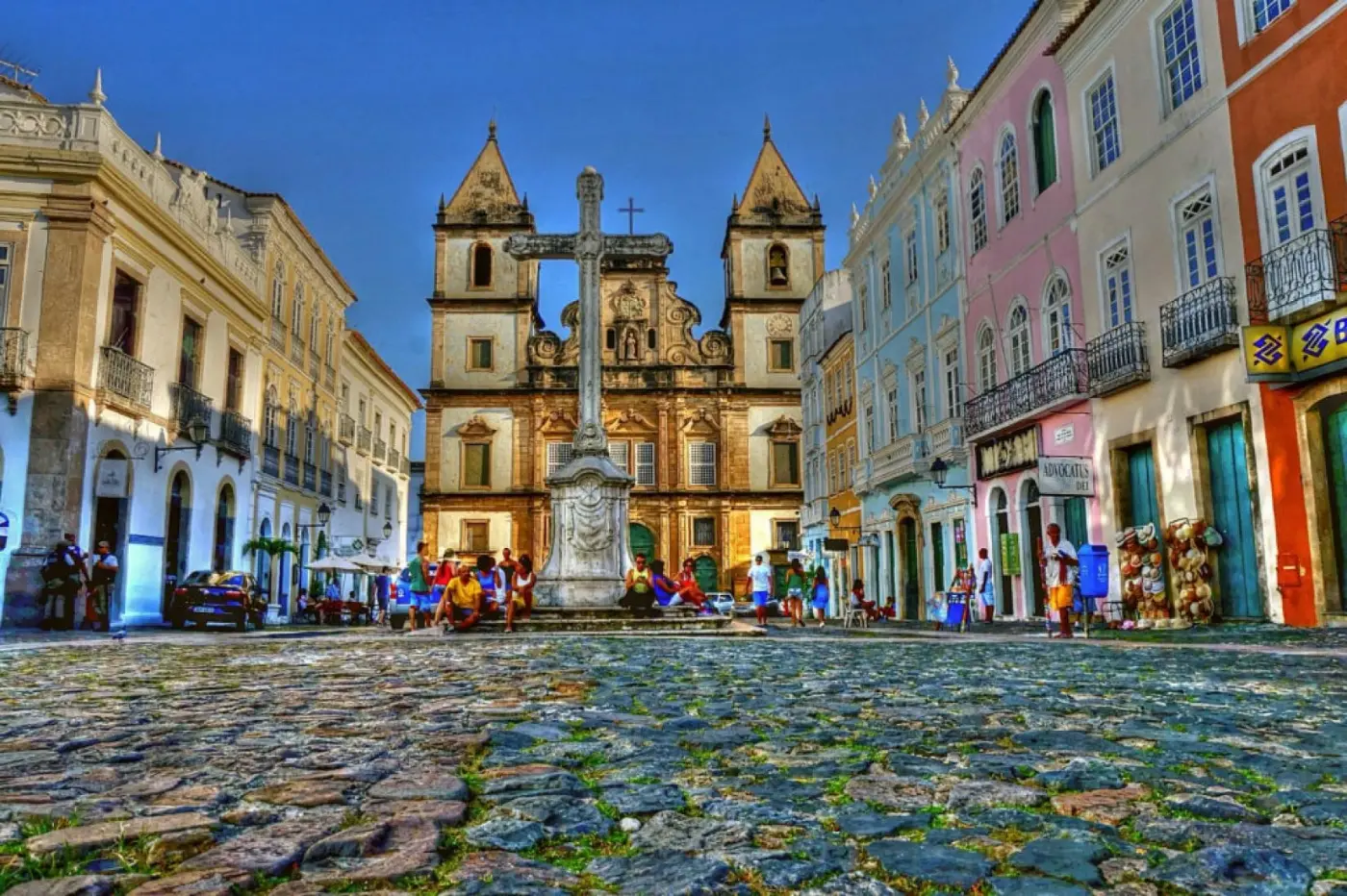 The Pelourinho historic centre in Salvador, Bahia: a cobbled square with a stone cross, a baroque church and pastel colonial facades